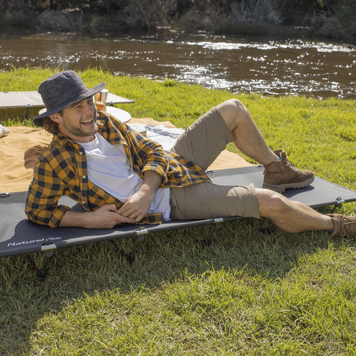 - Vīrietis baudot dabu un atpūšoties uz Naturehike XJC05 Outdoor Folding Camping Bed gaitenī pie ūdens tilpnes
- Compactly folded Naturehike gulta piedāvā komfortablu gulēšanu brīvā dabā
- Mitrumizturīgs un stabils dizains, izgatavots no augstas kvalitātes Oxford auduma un 7075 alumīnija
- Ideāla izvēle kempingiem, pārgājieniem un atpūtai dabā
- Naturehike