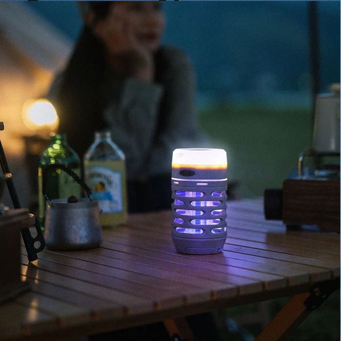 - "Naturehike Outdoor USB Rechargeable Electric Mosquito Killer Lamp khakī krāsā atrodas uz kempinga galda, tumšs fonā ar violetu gaismu"
- "Mazais LED UV-camp lampas dizains ar diviem apaļiem pakaramajiem"
- "Lampas mirdzošā violetā gaisma pievelk moskītu uzmanību un efektīvi noguldina tos ar augstsprieguma režģi"
- "IP44 ūdensizturības standarts, USB-C uzlādes ports"
- "Ideāli piemērots āra aktivitātēm un kempinga telts apgaismojumam"

Naturehike