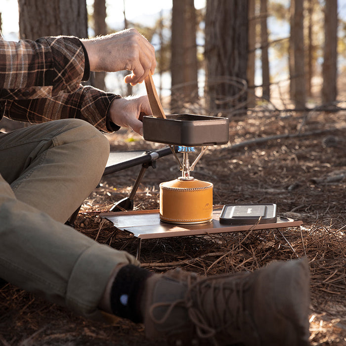 Tūrisma Gāzes Deglis
- Cilvēks, kas izmanto Naturehike Ultralight Backpacking Stove Pro Trekking 51gr gāzes plīti mežā.
- Gāzes plīts tiek izmantota ēdiena gatavošanai uz kempinga vietas.
- Mazs un kompakts dizains ar augstu varu ideāls tūristu pārgājieniem.
- Plīts izgatavota no vara, nerūsējošā tērauda un alumīnija materiāla.
- Gadījums dabā, kas demonstrē produkta praktiskumu un daudzfunkcionalitāti.
- Naturehike