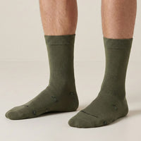 Green socks worn by a person on a beige background