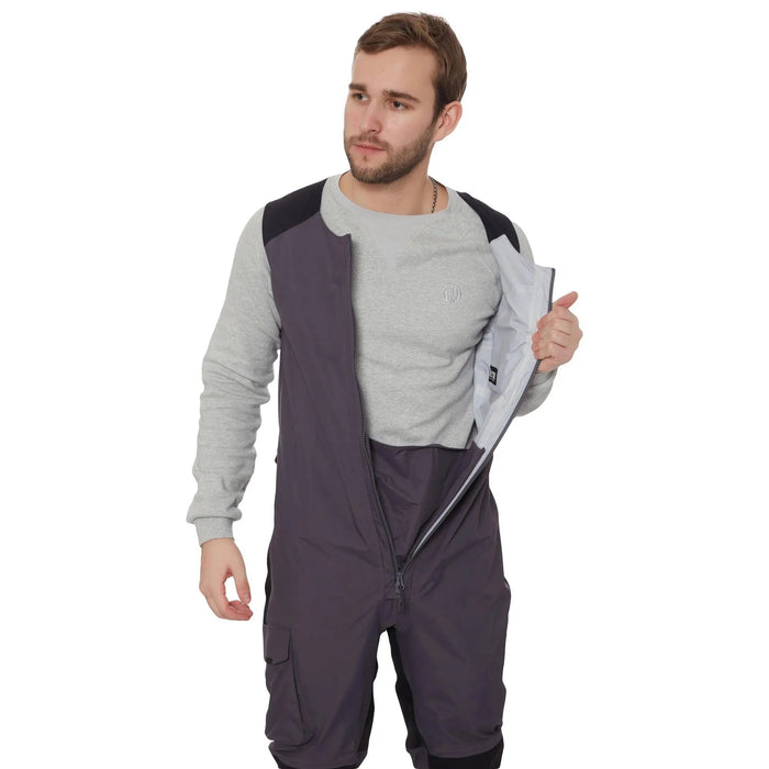 - Vīrietis, kas valkā FHM Guard Competition Waterproof Fishing Pants 20000mm Grey, demonstrē, kā tiek atverta centrālā priekšējā rāvējslēdzēja aizdare.
- Bikses ir pelēkas krāsas, ar melniem ielāpiem uz ceļiem un sēdvietas.
- Produkts ir radīts makšķerniekiem, kas attiecina uz augstu ūdensizturību, vēja un lietus pretestību.
- FHM