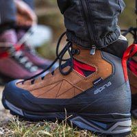 Kalnu zābaki Alpina Carabiner Classic ir paredzēti alpīnismam, stāviem piegājieniem un ziemas maršrutiem. Brūna krāsa skats dabā uz kājām.