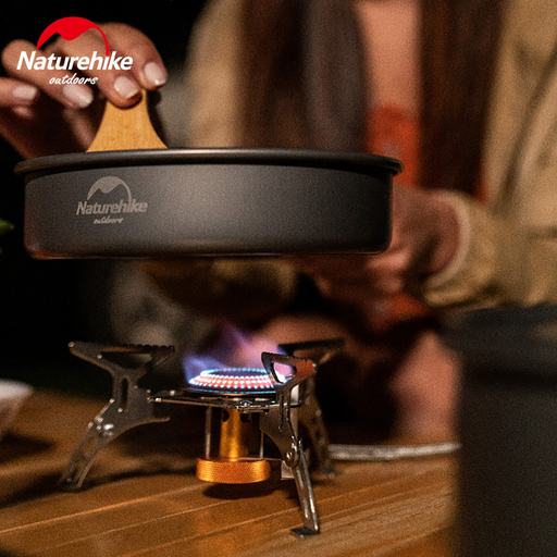 - Naturehike Ultralight Portable Gas Stove darbībā, ar liesmu šķiltaviņu un cepšanas pannu
- Pārnēsājama gāzes plīts piestiprināta pie galdiņa āra apstākļos
- Cilvēks izmanto Naturehike virtuvi, lai pagatavotu maltīti
- Kompakts gāzes degļu dizains piemērots kempingiem un āra aktivitātēm
- Uzticams un efektīvs degvielas patēriņš īpaši viegliestiļu ceļojumu virtuvei
- Ideāls risinājums āra kempingiem, pārgājieniem un piknikiem
- Materiāli: varš, nerūsējošais tērauds un alumīnija sakausējums

Naturehike